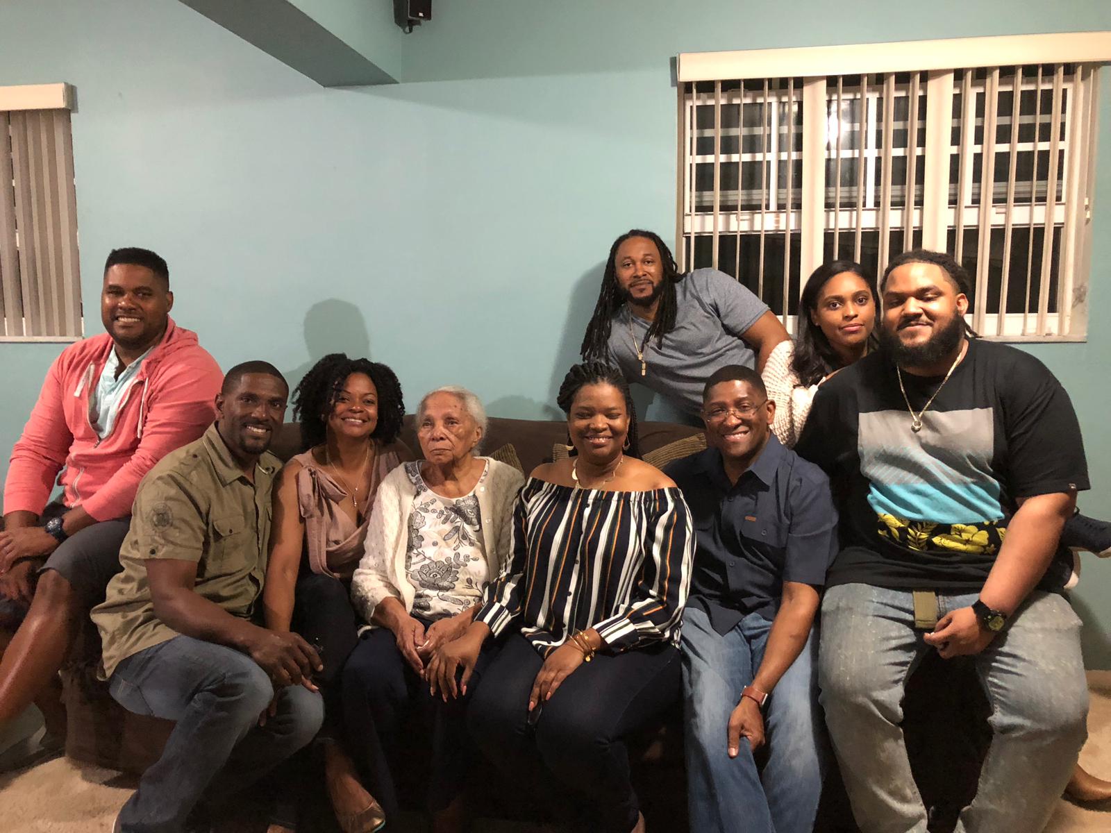 Daisy surrounded by her loving grandchildren and family gathered together on a couch